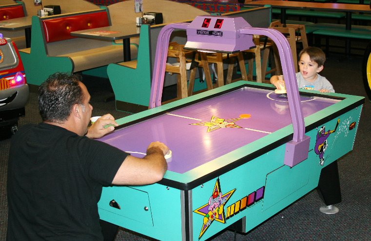Nicholas plays air hockey with Daddy